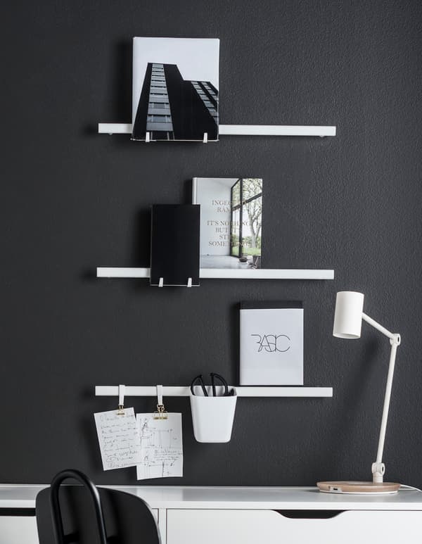 Organise your wall! IKEA has the products you are looking for. Display books and note books on a rail, such as the IKEA SUNNERSTA rail. Add sketches and a container for pens using clips and hooks.