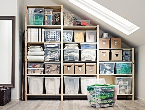 Organised storage under slanted ceiling with IVAR shelving unit and SAMLA storage boxes.