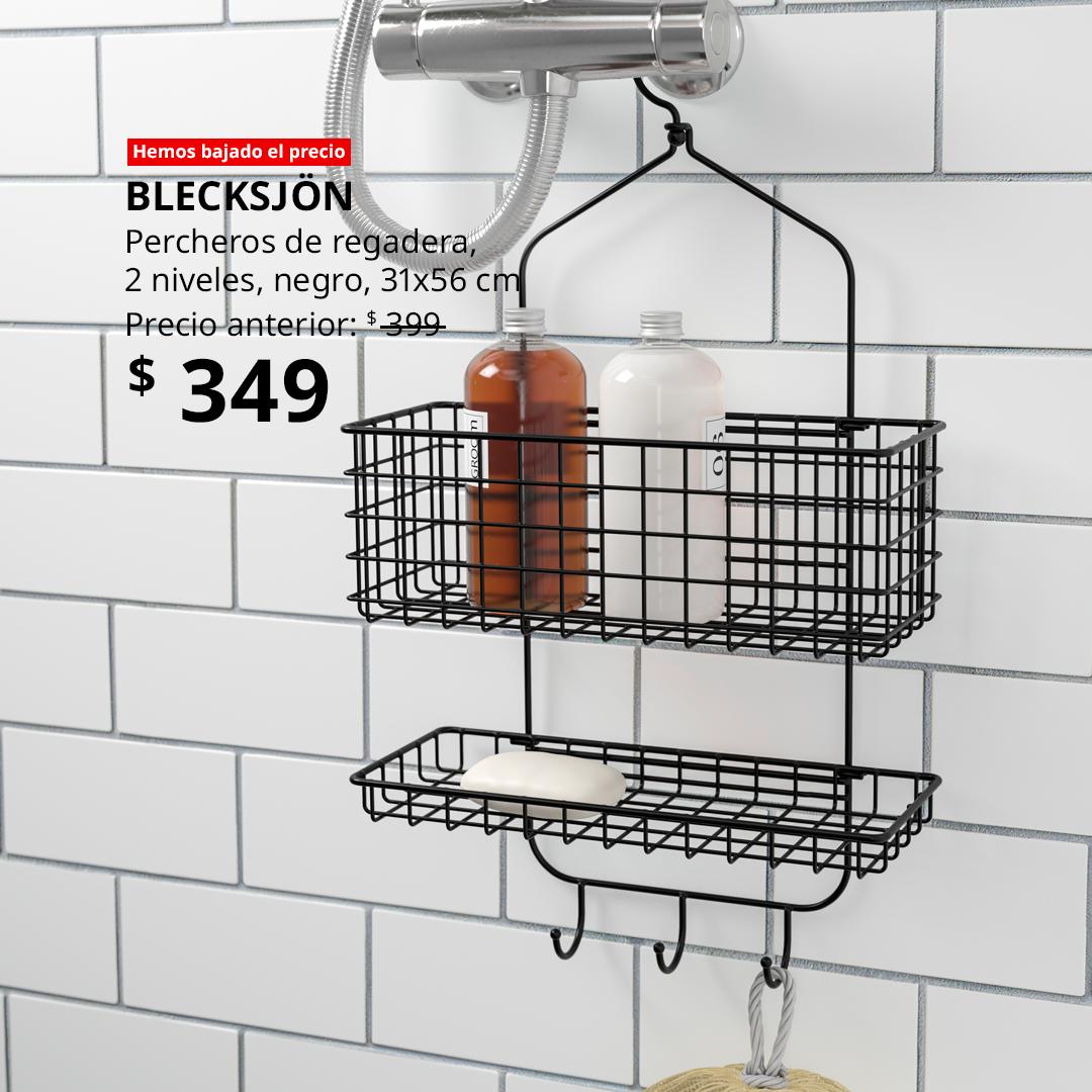Organizador de regadera BLECKSJÖN negro colgado en grifo plateado, dos repisas con botellas de shampoo y acondicionador, barra de jabón en canasta inferior y ganchos para accesorios; diseño práctico y moderno para baño con azulejos blancos.