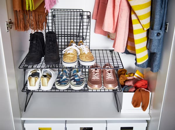 Organizează pantofii și hainele cu ajutorul suportului pliabil pentru pantofi GREJIG de la IKEA, negru.  Stivuiește până la trei astfel de suporturi solide cu plasă și pliază-le dacă vrei să le dai deoparte. 