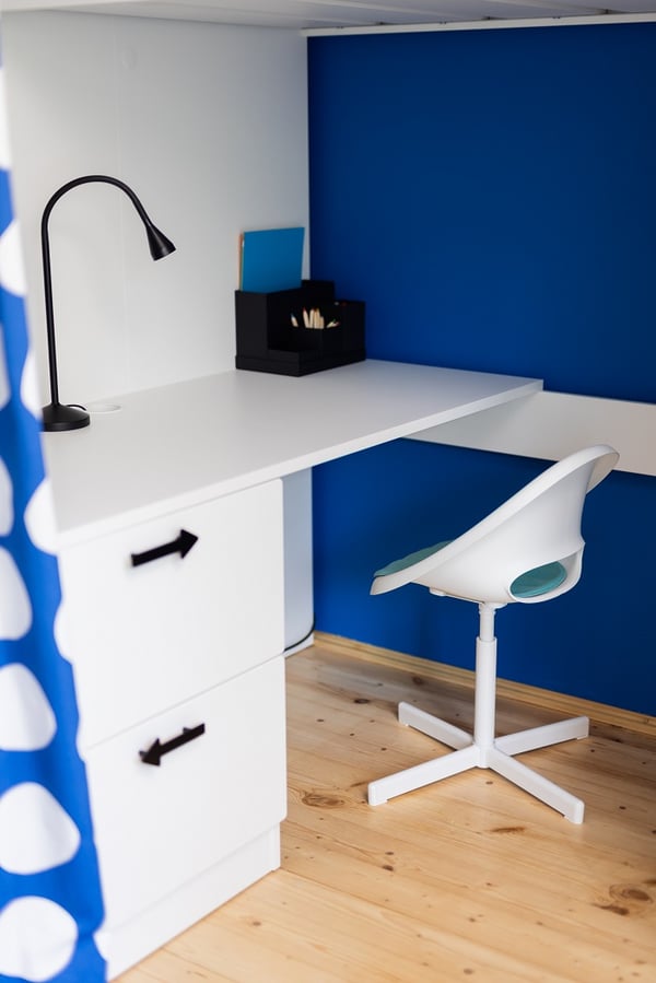 Организованная система хранения для детей с книгами, коробками и белыми дверцами шкафов