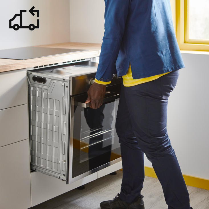 Osoba instalující troubu do nové kuchyně.