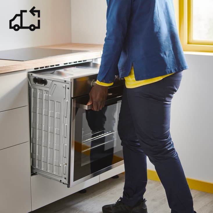 Osoba, ktorá inštaluje rúru v novej kuchyni.
