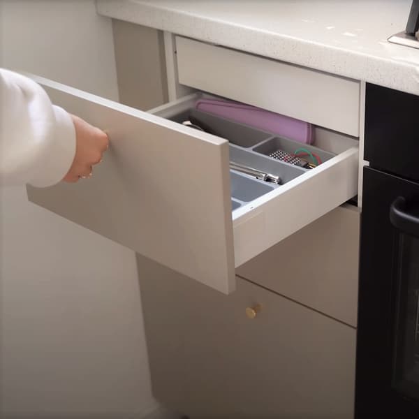 Osoba otwierająca szufladę kuchenną.