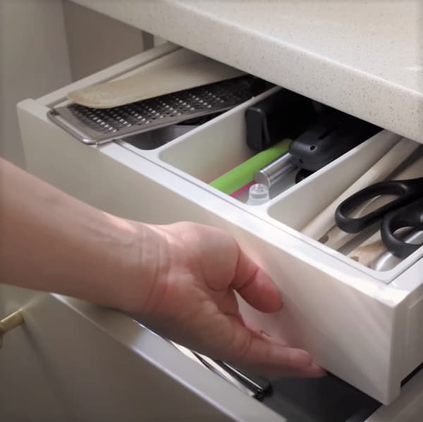 Osoba otwierająca wewnętrzną szufladę kuchenną MAXIMERA.