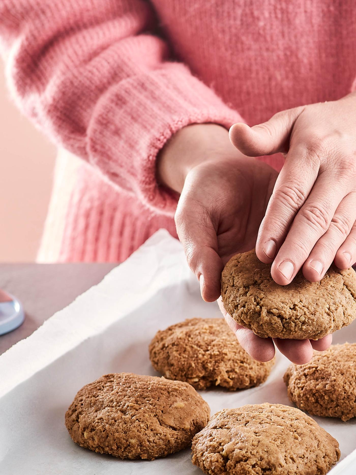 Osoba v ružovom svetri tvaruje z bezmäsitej zmesi VÄRLDSKLOK hamburgery.