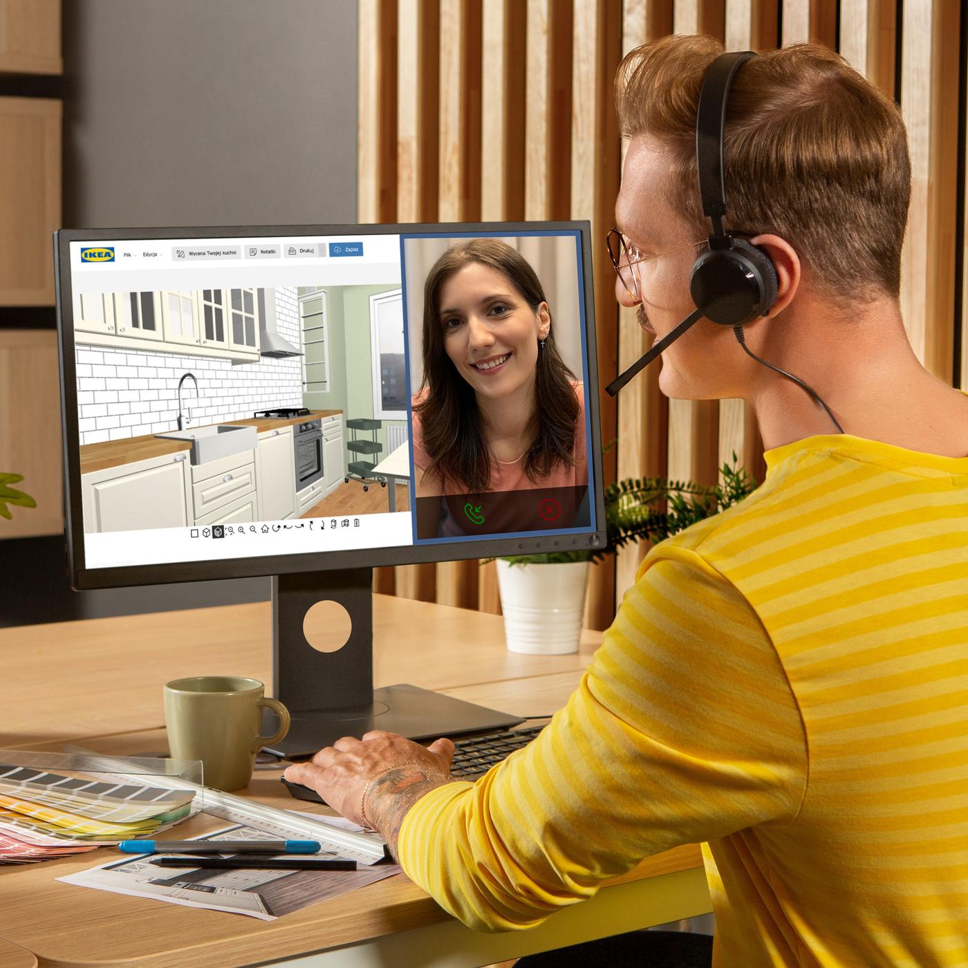 Osoba w odzieży służbowej IKEA siedzi przed komputerem prowadzi spotkanie online z klientką i planuje dla niej kuchnię w narzędziu do planowania.