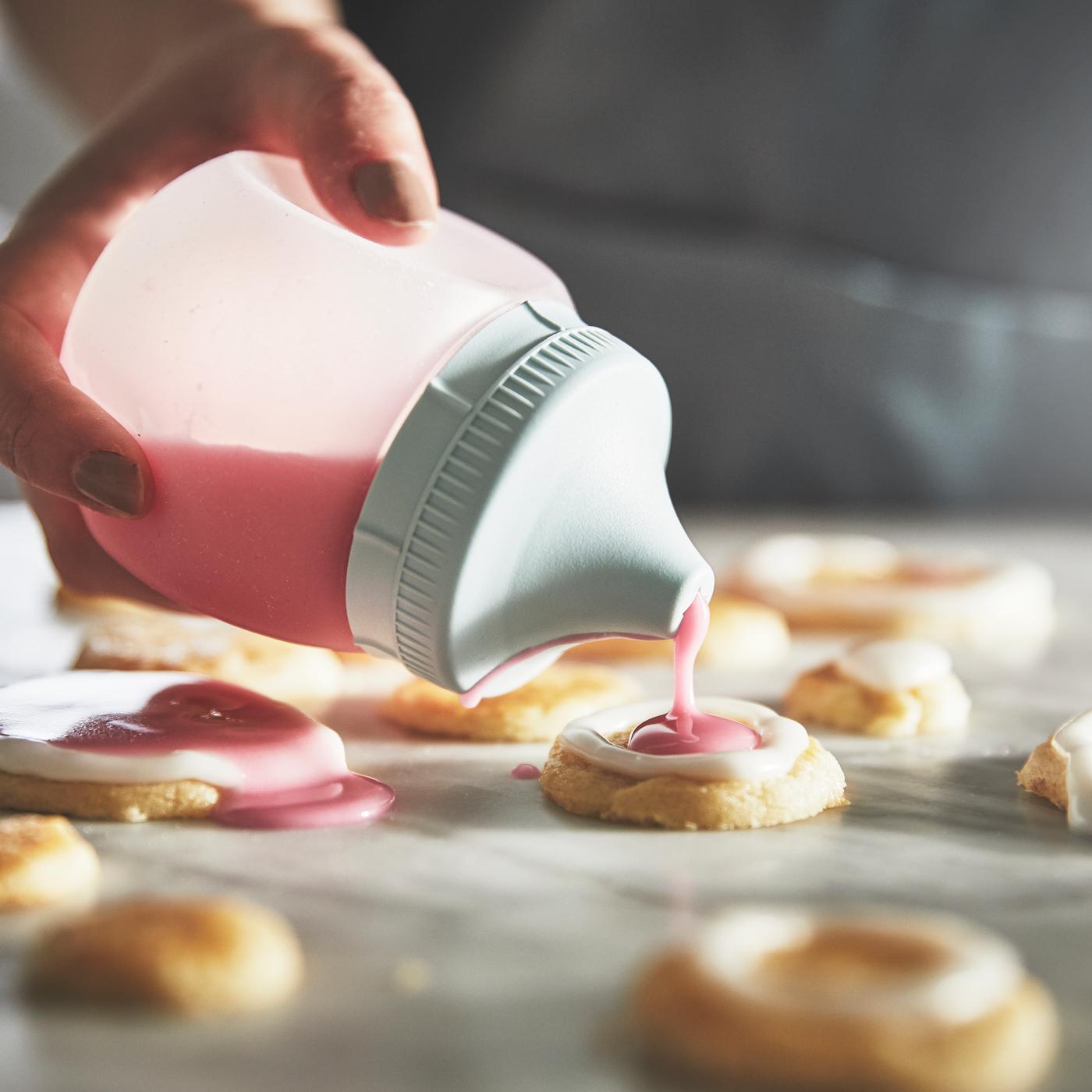 Osoba wyciska lukier na ciasteczka za pomocą rękawa z zestawu do dekoracji ciast GARNITYREN