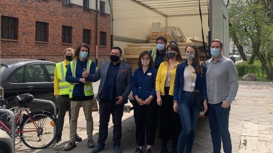 Osoby z IKEA i Fundacji Wolne Media stoją przed ciężarówką z produkatmi do sklepu socjalnego.