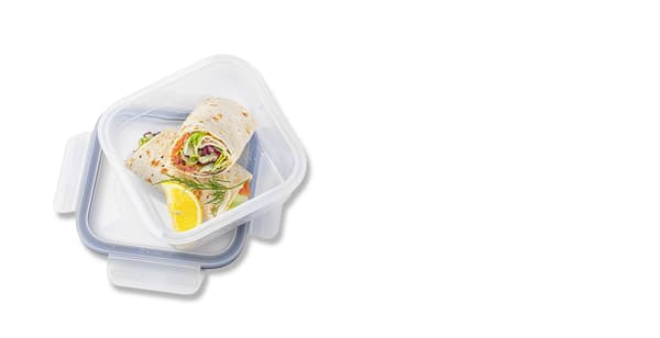 Otevřená dóza s víkem. V ní je wrap s lososem a citronem.