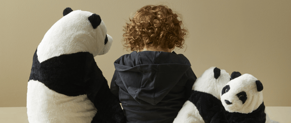 Otrok in plišaste igače - medvedi panda.