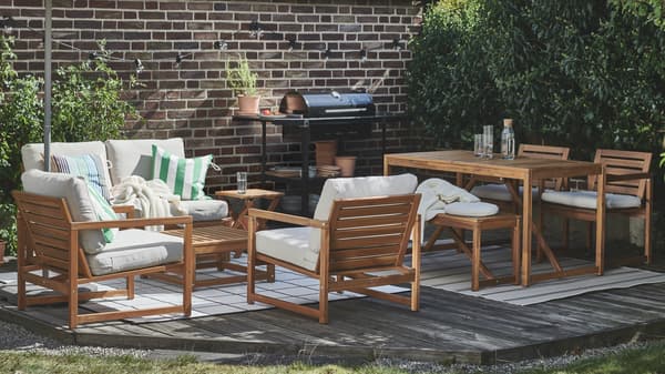 Outdoor-Sitzmöglichkeiten: Es ist ein Außenbereich mit einer NÄMMARÖ 4er-Sitzgruppe und einem GRILLSKÄR Kohlegrill mit zwei Beistelltischen zu sehen.