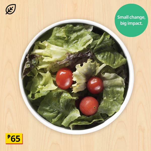 Overhead view of fresh lettuce and three red tomatoes in a white bowl on wood, with “Small change, big impact” badge and ₱65 price.