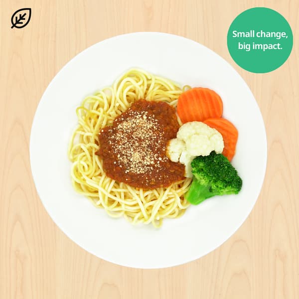 Overhead view of spaghetti topped with meat sauce and breadcrumbs, served with carrots, cauliflower, and broccoli on a white plate; cheerful healthy-eating message.