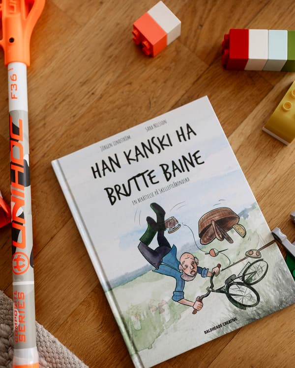 På ett bord ligger en bok, en innebandyklubba och några byggklotsar.