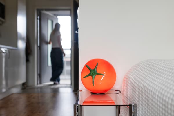 På ett bord står en röd lampa i form av en tomat. 