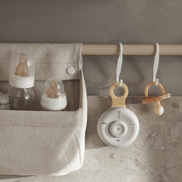 Pacifiers and other baby items hang on a rack