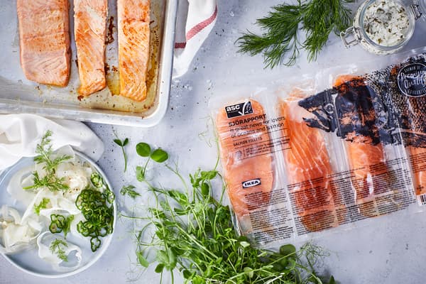 Packaged and cooked SJÖRAPPORT salmon served alongside various greens.