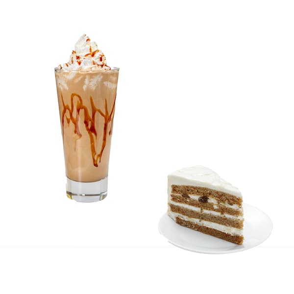 Pahar cu cafea decorat cu frișcă și sos de caramel, lângă o felie de tort cu cremă albă și blat maro, pe o farfurie albă.