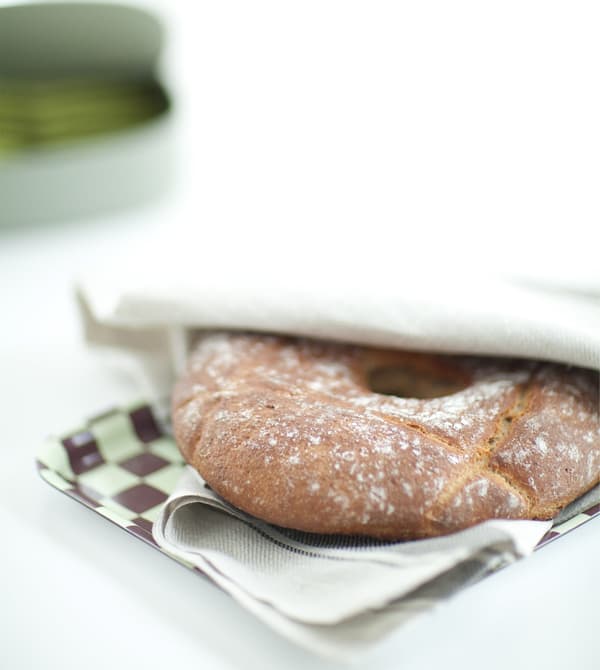 Pain rustique emballé dans un torchon et posé sur un plateau.