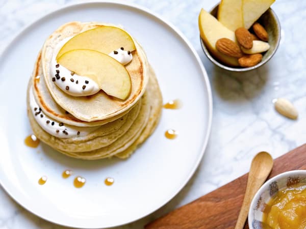 Pancakes mit Apfelmus auf einem Teller präsentiert.