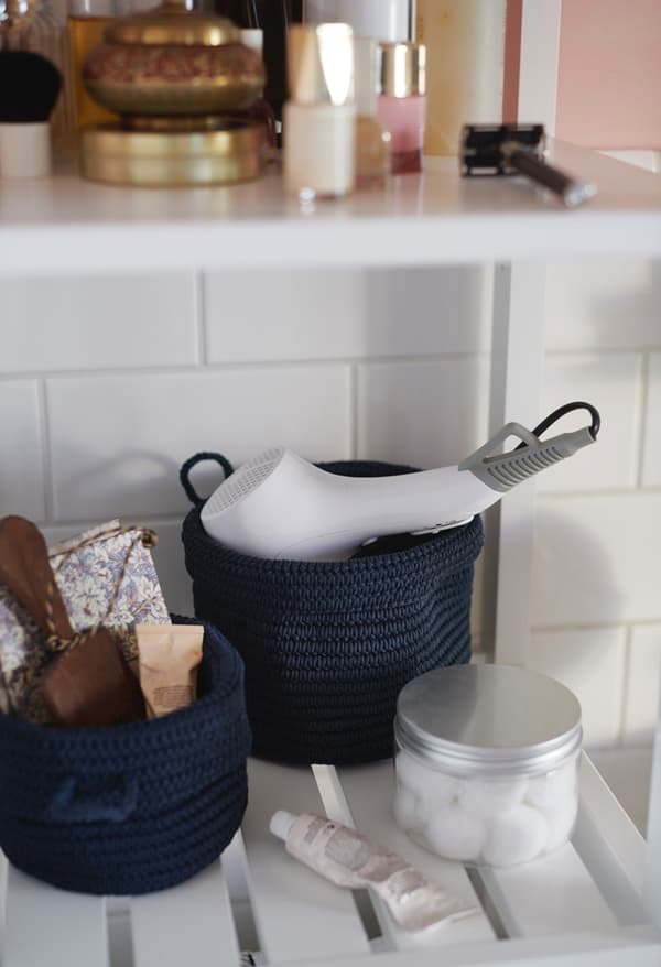 Paniers NORDRANA contenant un sèche-cheveux et autres affaires de toilettes