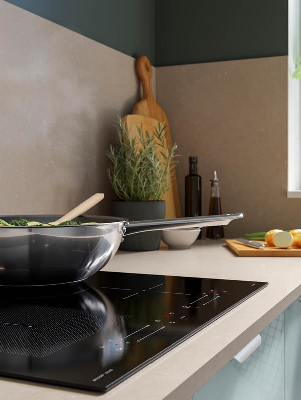 Panvica wok IKEA 365+ je na indukčnej varnej doske SMAKLIG.