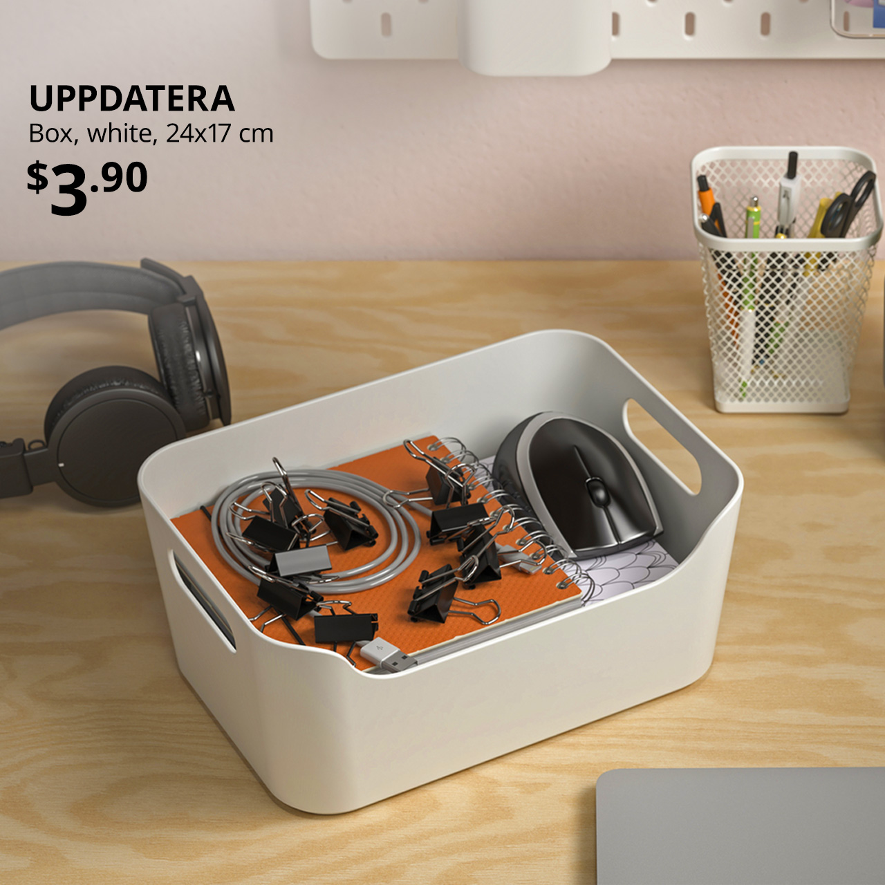 Paper clips, laptop mouse and notebooks stacked within a white UPPDATERA box on a desk. $3.90