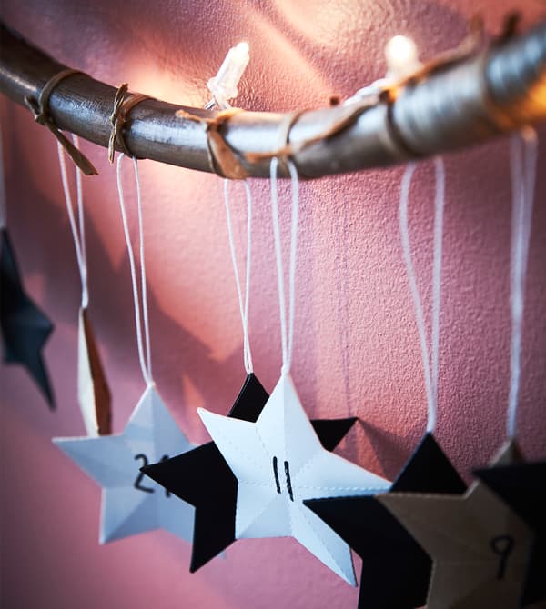 Paper stars hang from a decorated hula hoop.