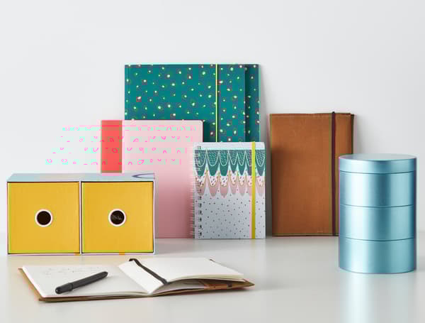 Papers de color metal·litzat i pastel disseminats sobre una taula.