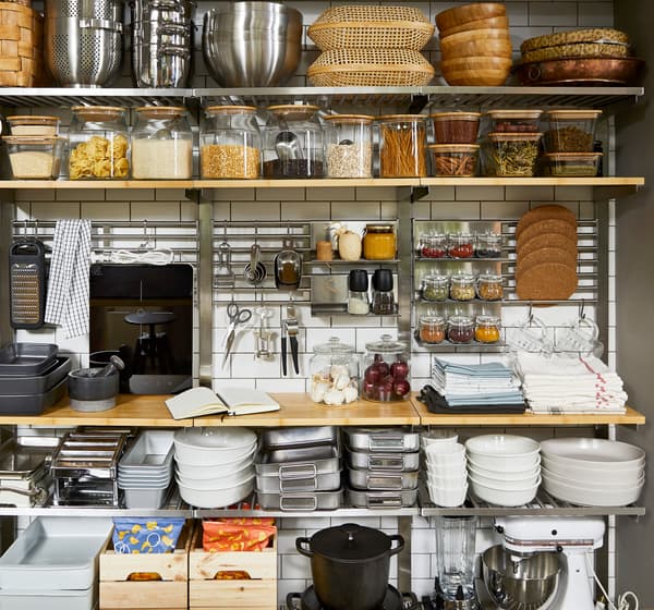 Para dapur terbuka yang dibuat daripada kayu, peralatan dapur seperti hob aruhan mudah alih TILLREDA dan tempat letak tablet KUNGSFORS yang mempunyai herba.