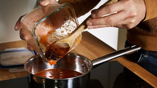 Paradicsomszószt öntenek egy IKEA 365+ ételtárolóból.