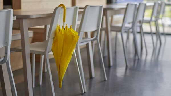 Parapluie jaune sur chaise blanche