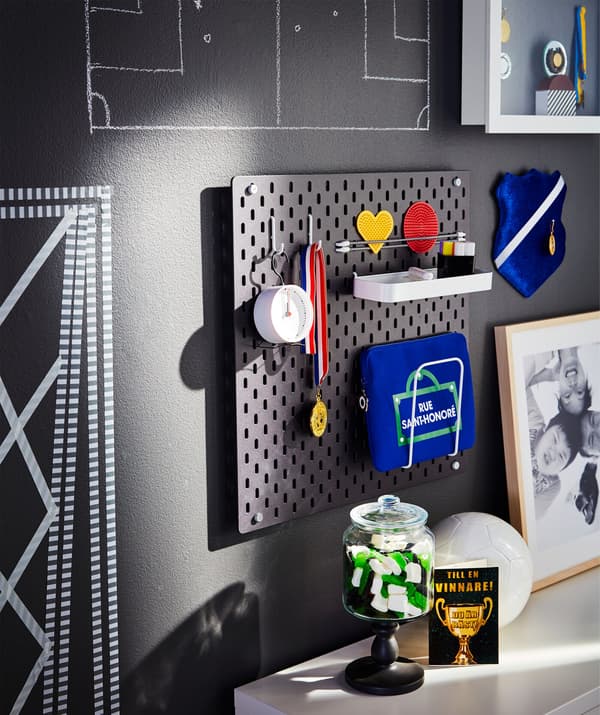 Parede decorada cun escudo de fútbol, unha medalla e outros elementos futbolísticos