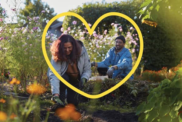 Pareja recolectando flores con un corazón pintado en amarillo por encima de la foto.