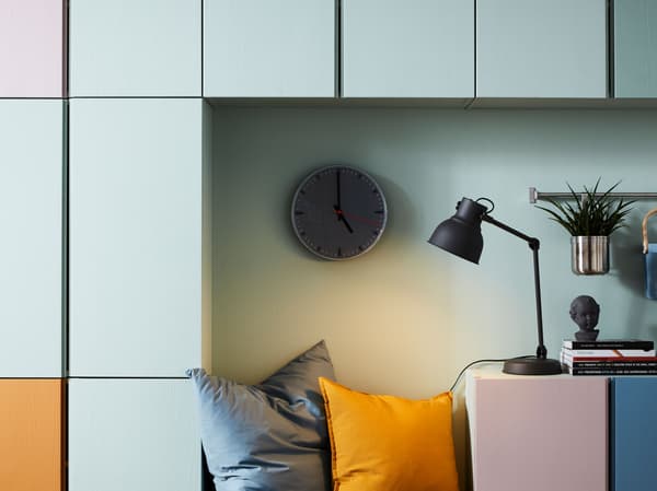 Parete con combinazione di mobili IVAR in diversi colori, fra cui arancione, bianco, blu e rosa, usati per distinguere i contenuti.