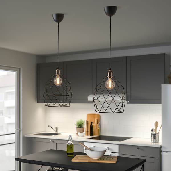 Part d’una cuina en tons blanc i gris amb dues llums de sostre geomètriques i bombetes LED.