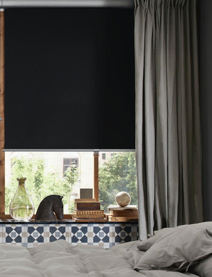 Part of a bedroom with two TRETON block-out pleated blinds, half-way down, in two windows above low chests of drawers.