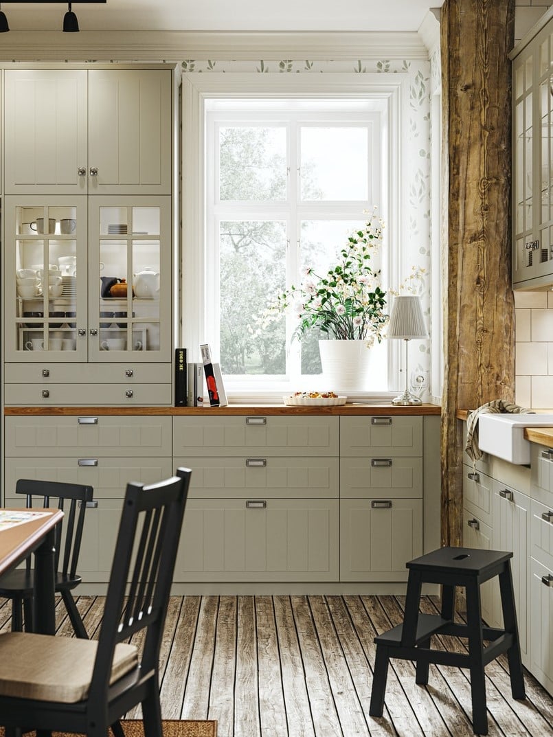 Particolare di cucina beige con  istema componibile METOD, con frontali e ante STENSUND beige. Sul piano di legno un impasto dentro una tortiera e una lampada da tavolo ÅRSTID.