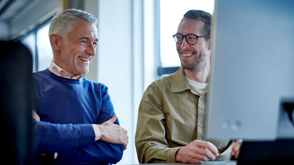 パソコンの前で二人のコワーカーが話している