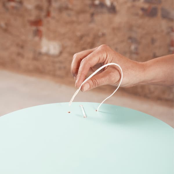 Pass a fine nylon thread through the holes to form the cross-stitch.