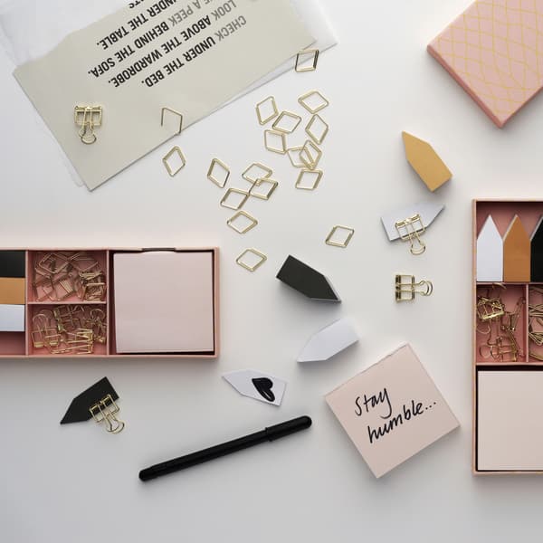 Pastel-coloured and metallic stationery scattered on a table.