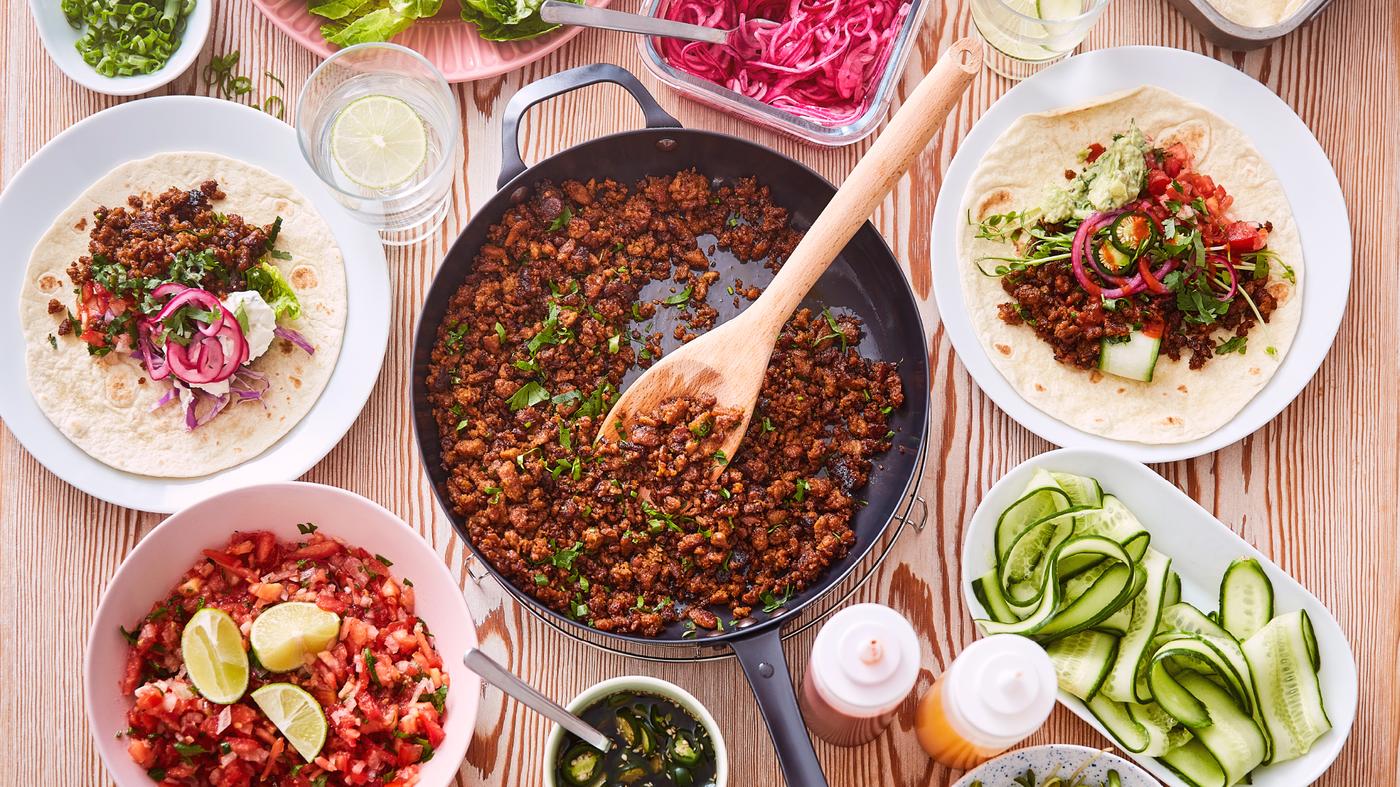 Patelnia z mielonką warzywną taco VÄRLDSKLOK obok talerzy i misek z salsą Pico de Gallo i tortillami.