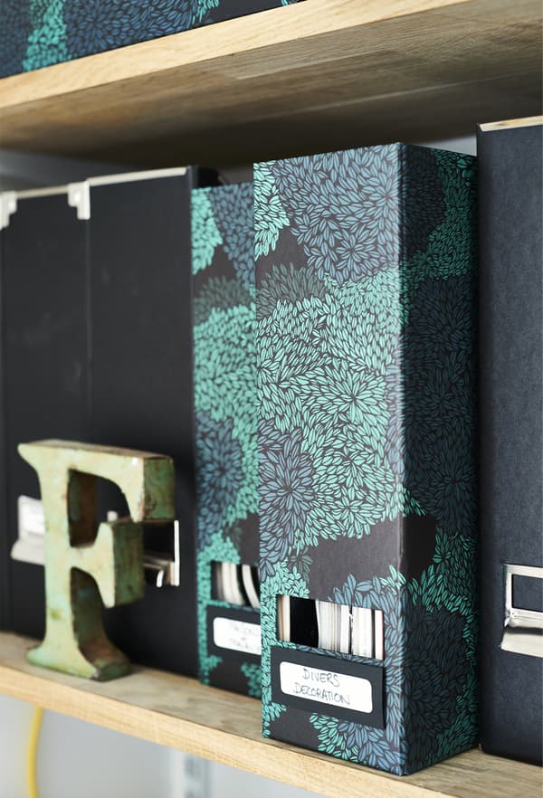 Patterned box files on a shelf.