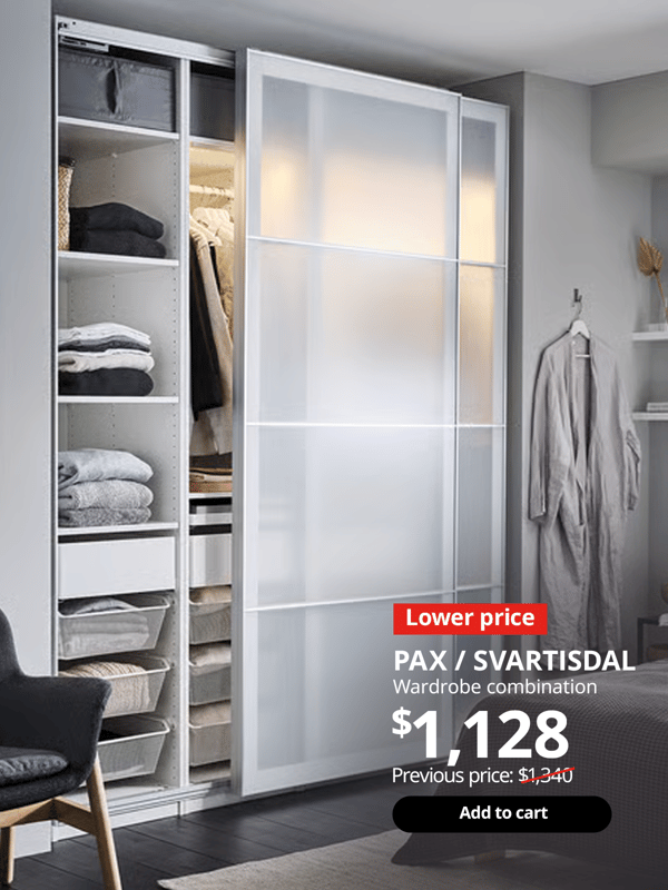 PAX wardrobe combination in the bedroom with SVARTSIDAL paper-effect sliding doors half open, showing clothes neatly folded on the shelves in the wardrobe. 