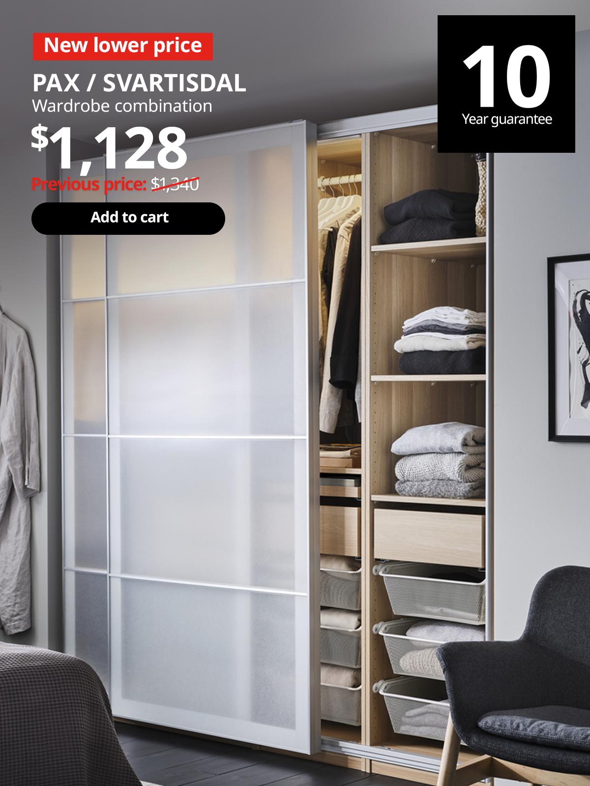 PAX wardrobe combination in the bedroom with SVARTSIDAL paper-effect sliding doors half open, showing clothes neatly folded on the shelves in the wardrobe. 