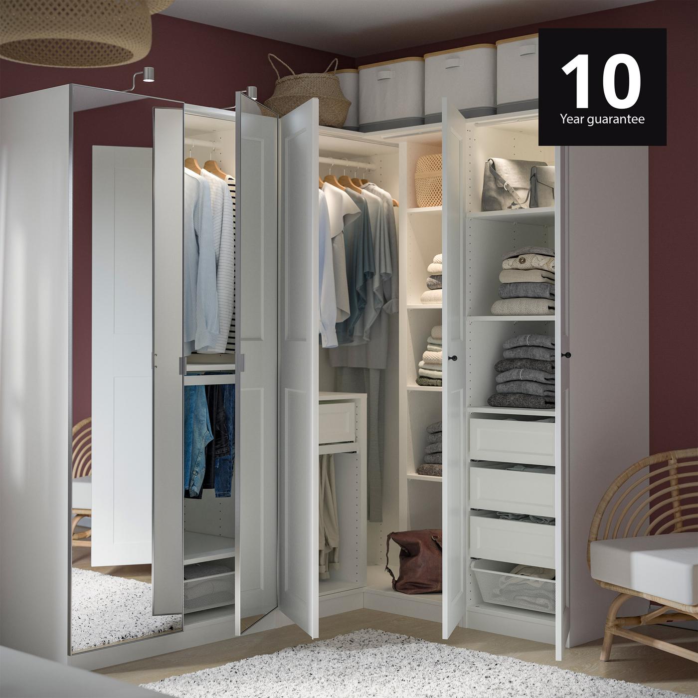 PAX wardrobe in bedroom with integrated lighting and armchair next to it.