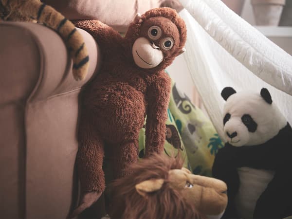 Peluche DJUNGELSKOG: un panda, un leone e un orango accanto ad una poltrona, Dietro di loro si intravede una tenda bianca. 