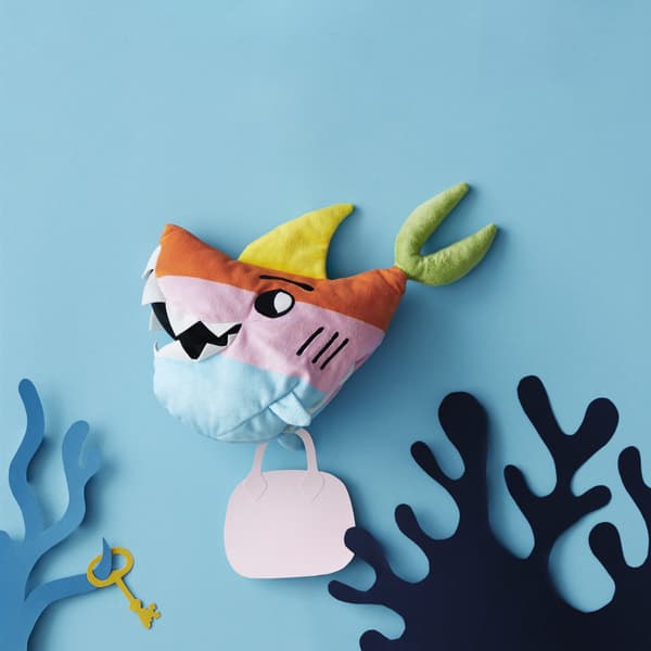 Peluche en forme de requin dans un décor sous-marin en papier.