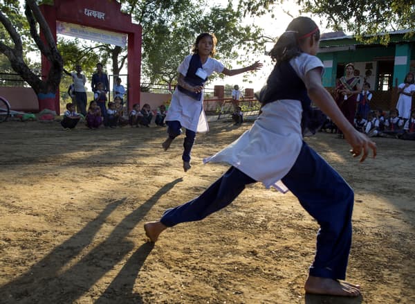 Pemandangan lewat petang di ruang luar di negara Timur menunjukkan budak perempuan sedang bermain di laman sekolah.